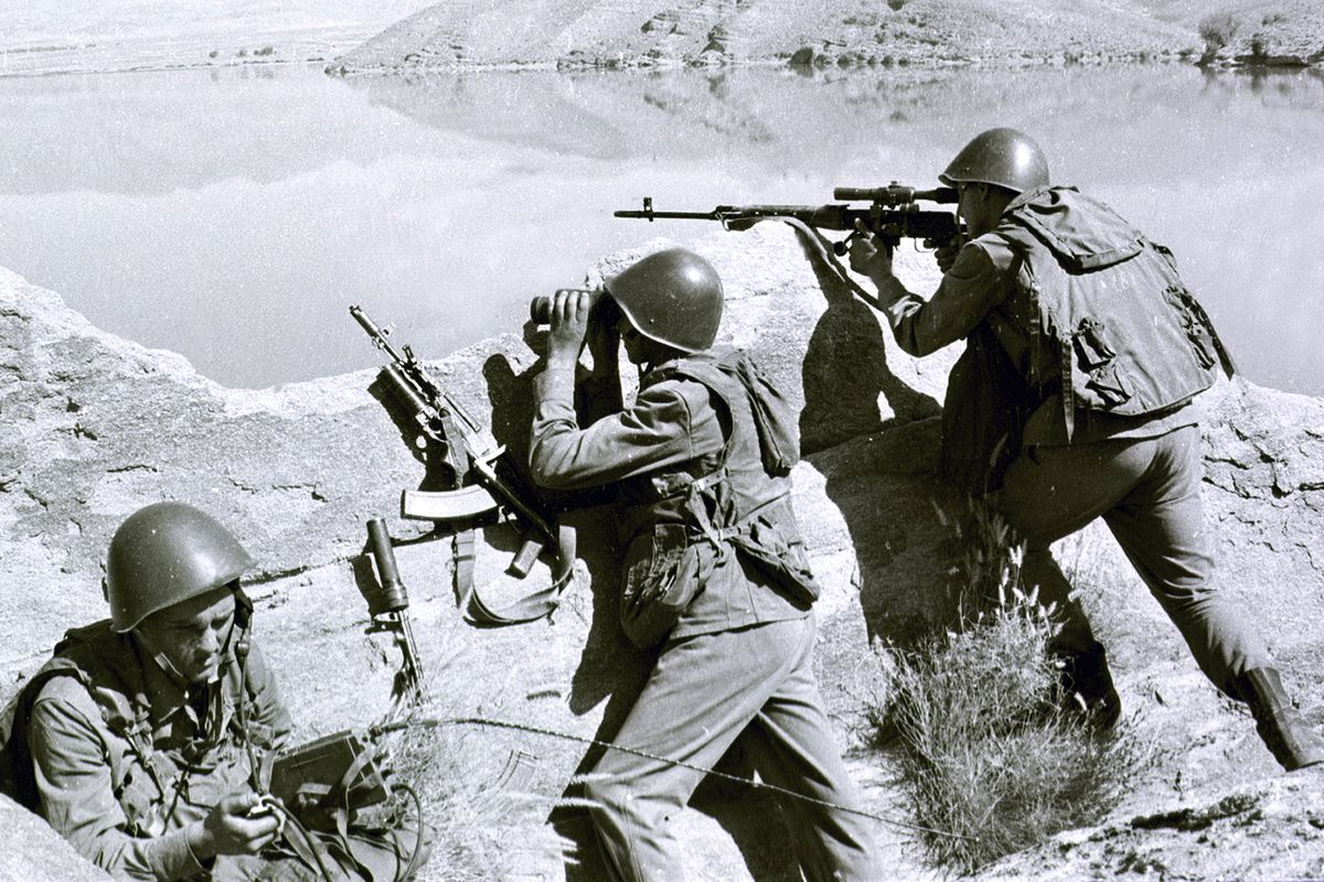 FILE - In this late April 1988, file photo, Soviet soldiers observe the highlands, while fighting Islamic guerrillas at an undisclosed location in Afghanistan. Moscow and Washington are intertwined in a complex and bloody history in Afghanistan, with both suffering thousands of dead and wounded in conflicts lasting for years. Now both superpowers are linked again over Afghanistan, with intelligence reports indicating Russia secretly offered bounties to the Taliban to kill American troops there. But analysts suggest that the two adversaries actually have more in common, especially when it comes to what they want to see in a postwar Afghanistan: a stable country that does not serve as a base for extremists to export terrorism. Both countries also are aligned in their opposition to militants from the Islamic State group.  (Alexander Sekretarev)