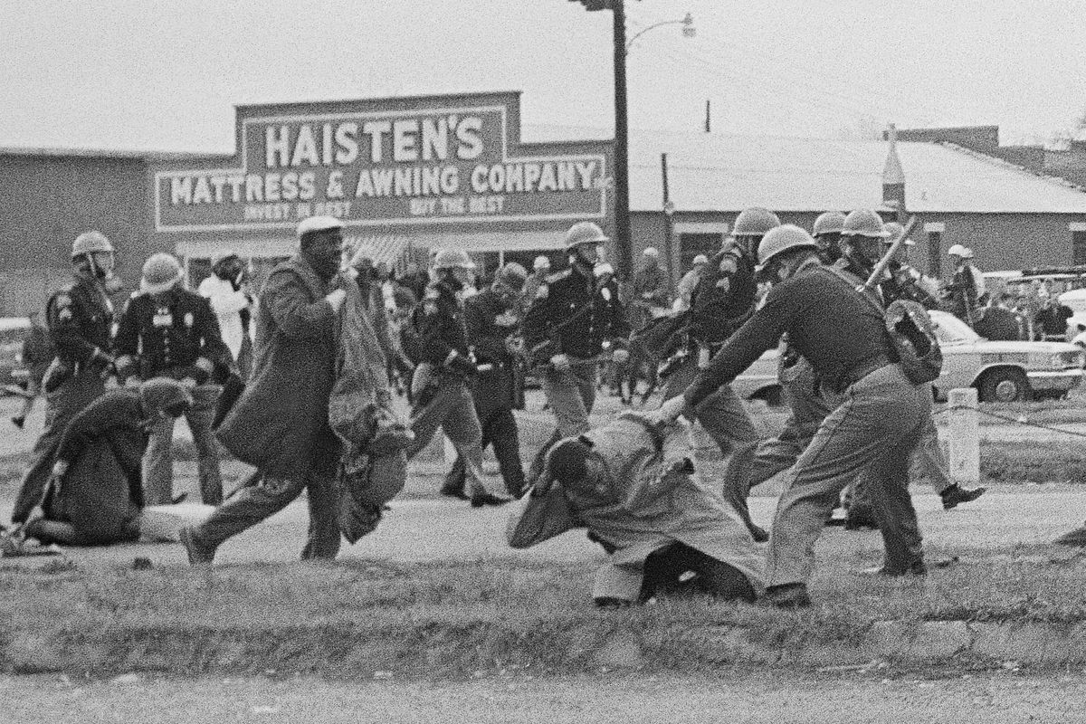 A state trooper swings a billy club at John Lewis, right foreground, chairman of the Student Nonviolent Coordinating Committee, to break up a civil rights voting march on March 7, 1965, in Selma, Ala.  (unknown)
