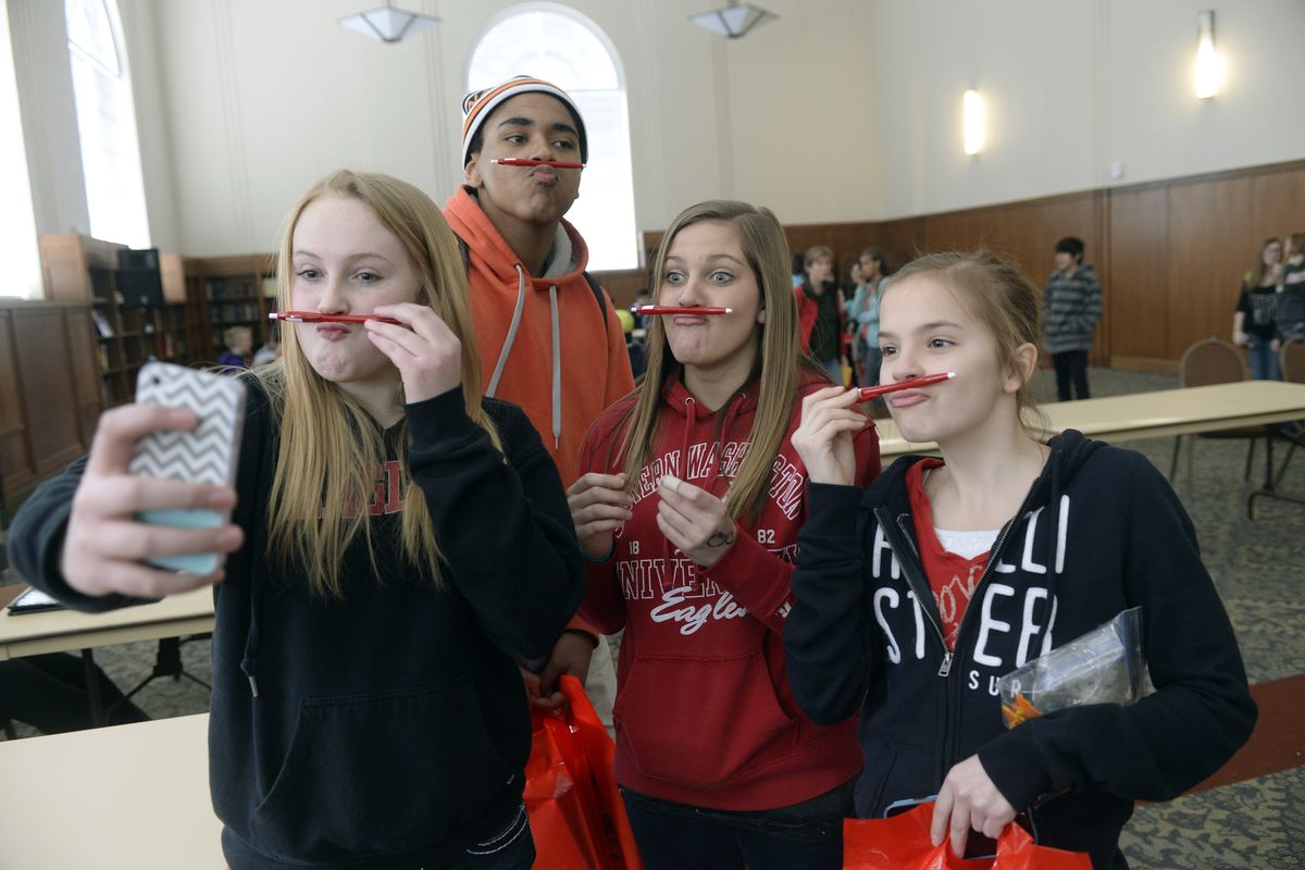 Eighth-graders from Cheney Middle School, from left, Ashley Barthels, Kali McCormick, Carisa Wahl and Shylee Chapman clown around with their souvenir pens for a selfie inside the reading room in Hargreaves Hall while visiting Eastern Washington University on Tuesday. Eighth-grade students from around the region visited EWU to learn about college life. (Jesse Tinsley)