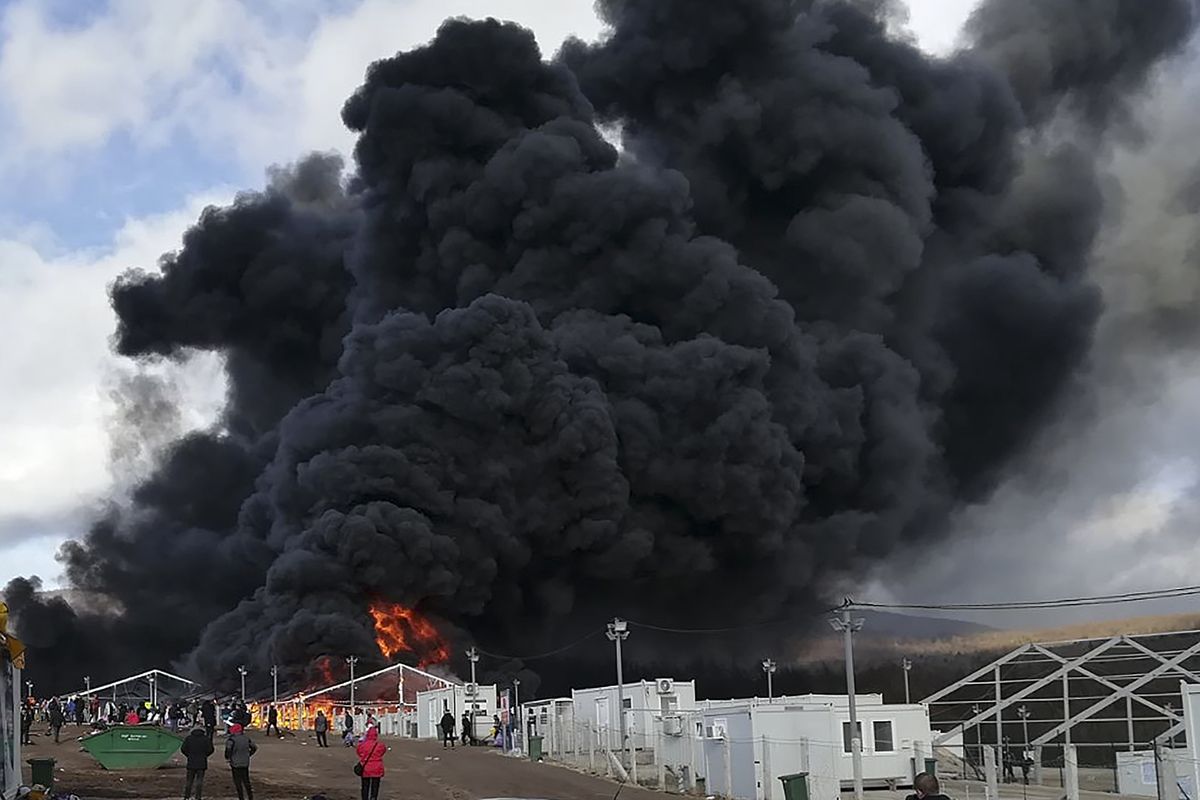 Smoke rises from a fire at migrant camp Lipa, Wednesday, Dec 23, 2020, near Bihac in western Bosnia. A huge fire has broken out at a migrant camp in northwestern Bosnia which has been in the focus of rights groups because of poor conditions in the tent facility.  Thick black smoke could be seen rising Wednesday from parts of the Lipa camp near the Croatian border which currently houses some 1,200 migrants.  The cause of the fire was not immediately known as migrants were seen running away in panic. There were no reports of injuries.  (Hasan Arnautovic)