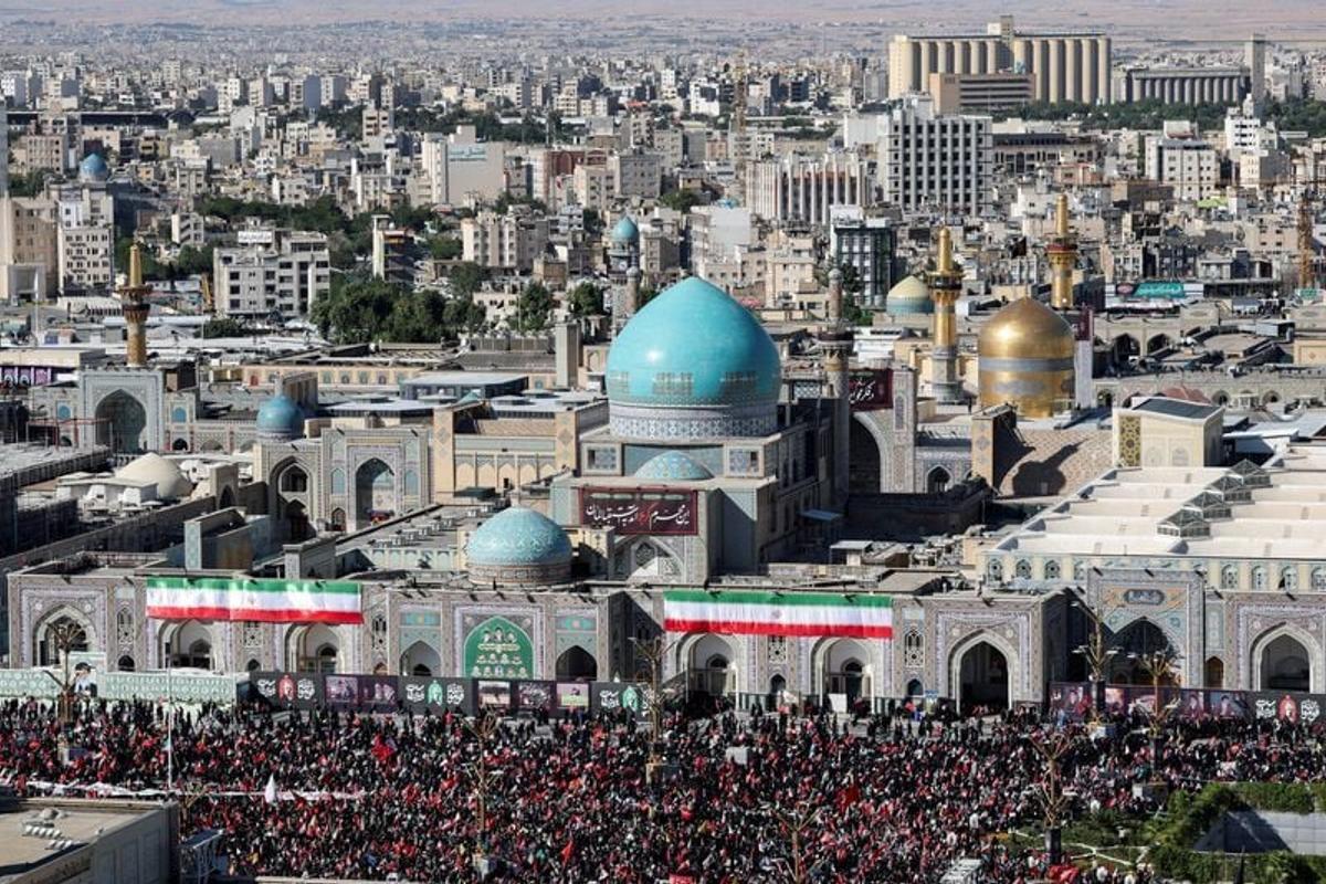 Mourners gather by Imam Reza shrine, on the day of of the burial of Iran