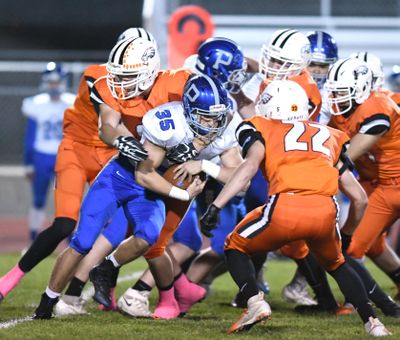 Pullman’s Ty Hendrickson  batters his way through West Valley defenders, including Ethan Rehn (22) on Friday, Oct. 12, 2018, at West Valley High School. Anacortes High School, a Class 2A program, has eliminated its football program because of low turnout. (Jesse Tinsley / The Spokesman-Review)