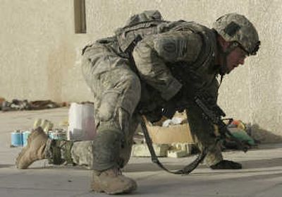 
A U.S. Army soldier from Charlie Company 1-27IN, 25th infantry crawls after the rooftop of Patrol Base Texas took sniper fire in southern Sadr City, Baghdad, on Thursday. Associated Press
 (Associated Press / The Spokesman-Review)