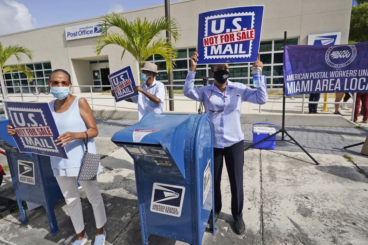 Protesters demonstrate during a "National Day of Action to Save the "Peoples" Post Office!" outside the Flagler Station post office, Tuesday, Aug. 25, 2020, in Miami. The pandemic has pushed the Postal Service into a central role in the 2020 elections, with tens of millions of people expected to vote by mail rather than in-person. At the same time, Trump has acknowledged he is withholding emergency aid from the service to make it harder to process mail-in ballots, as his election campaign legally challenges mail voting procedures in key states.  (Wilfredo Lee)