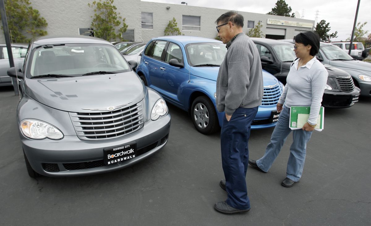 Customers look at PT Cruisers at a Chrysler dealership in Redwood City, Calif., on Tuesday. A federal bankruptcy judge granted the automaker’s request to sever ties with 789 dealerships such as this one. (Associated Press / The Spokesman-Review)