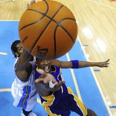Denver center Nene, left, blocks a shot by L.A.’s Kobe Bryant.  (Associated Press / The Spokesman-Review)