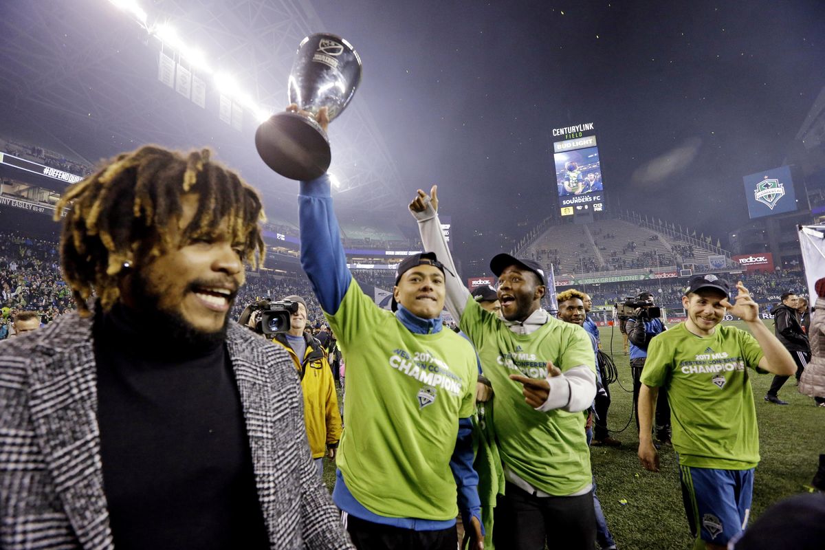 Seattle Sounders players cheer as one holds the conference trophy after the Sounders defeated the Houston Dynamo 3-0 in the second leg of the MLS soccer Western Conference final, Thursday, Nov. 30, 2017, in Seattle. The Sounders won an aggregate and advanced to the MLS Cup. (Elaine Thompson / Associated Press)