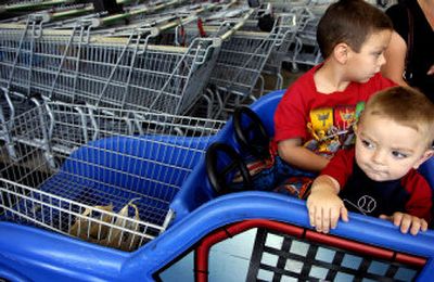 
Jesse Wirth, front, 22 months, sits with his  5-year-old brother J.J.  in a race car shopping cart while shopping with their mother at a Spokane Fred Meyer store Wednesday. Five Spokane-area children in a two-week period in August were injured badly enough in cart accidents to go to a hospital. 
 (Holly Pickett / The Spokesman-Review)