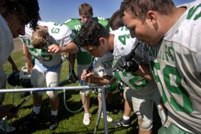 
East Valley High School defensive tackle John Roland, right, and the rest of the team take a water break between drills at football practice in Spokane Valley last week. 
 (Photos by HOLLY PICKETT / The Spokesman-Review)