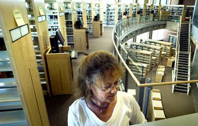 
 Dee Rodgers, one of the library's technical staff, helps organize shelves at Washington State University's new library at the Riverpoint campus on Monday. 
 (Joe Barrentine / The Spokesman-Review)