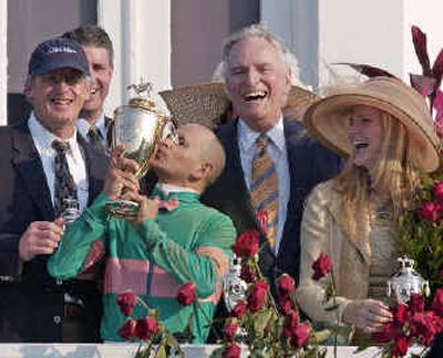 
Mike Smith, the jockey for surprise winner Giacomo, kisses the Kentucky Derby trophy on Saturday as trainer John Shirreffs, left, and owners Jerome and Ann Moss look on during ceremonies at Churchill Downs. 
 (Associated Press / The Spokesman-Review)