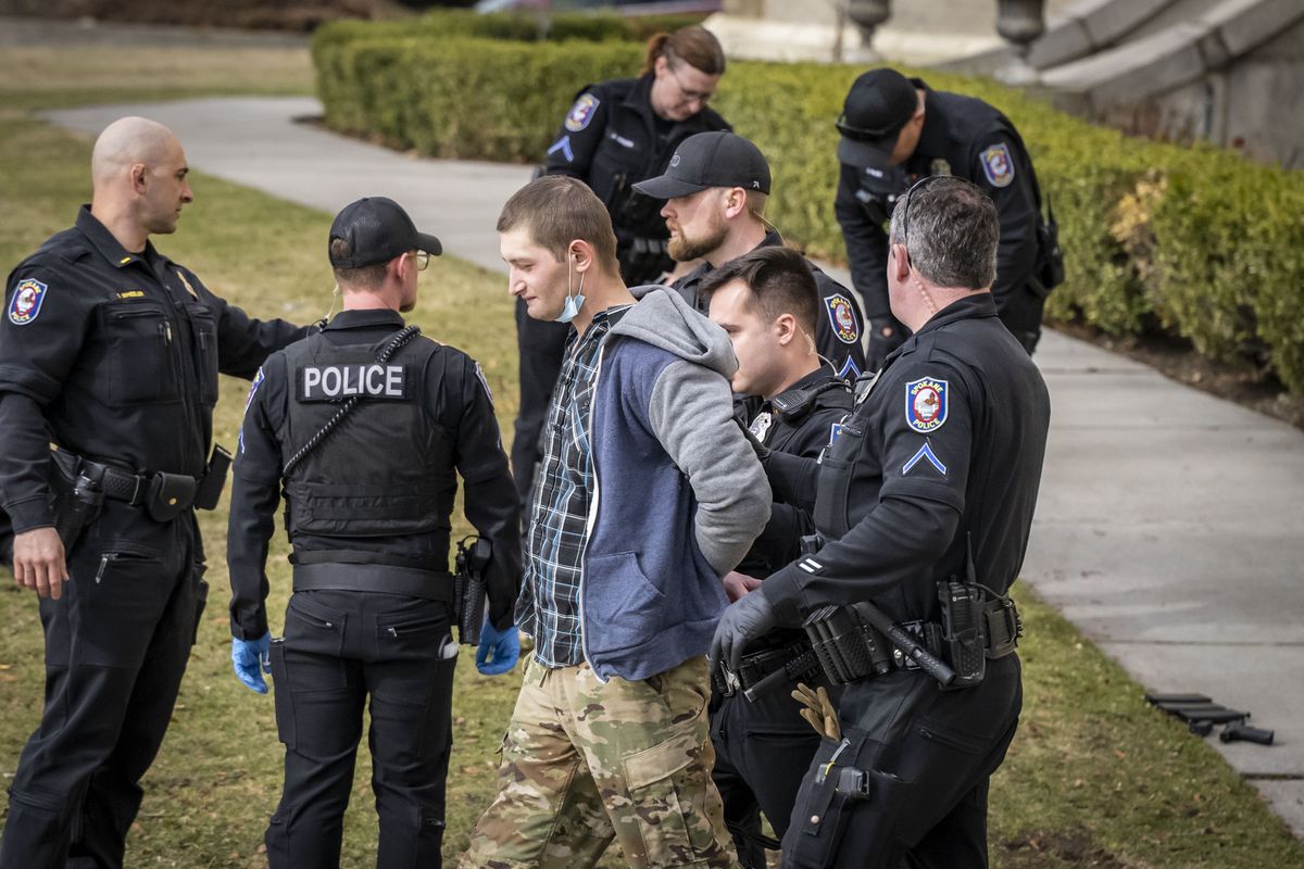 A man is taken into custody by Spokane Police officers Friday after being detained on the steps of the Spokane County Courthouse. The suspect allegedly was armed with an airsoft replica AR-15 assault rifle and pistol.  (COLIN MULVANY/THE SPOKESMAN-REVIEW)