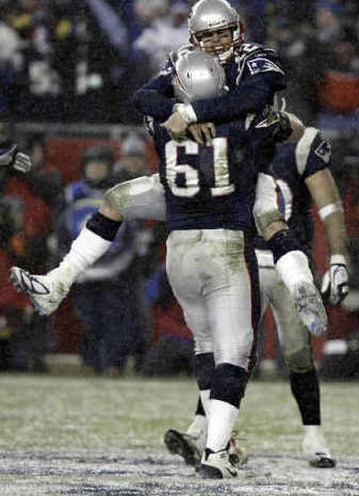 
New England guard Stephen Neal (61) gives a lift to QB Tom Brady during Sunday's playoff win over Indianapolis. 
 (Associated Press / The Spokesman-Review)
