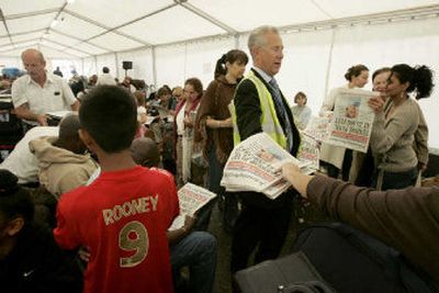 
People take copies of an evening newspaper Monday in a tent erected for passengers waiting to check in for their flights at Terminal 4 of London's Heathrow Airport. 
 (Associated Press / The Spokesman-Review)