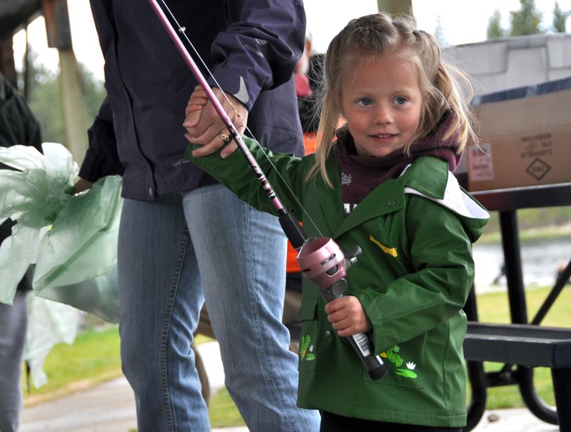 After receiving her free fishing rod, Kylee Hahn, 4, of Cheney wastes no time hauling her mom out to the beach at Clear Lake to try her hand at catching trout during the annual Kids Fish-In on May 1. (Rich Landers)