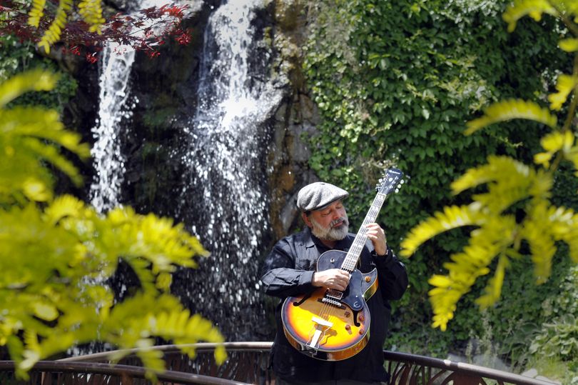 Guitarist Steven King plays near the waterfall in the Providence Center for Faith and Healing garden on the Sacred Heart Medical Center campus, where he is scheduled to perform in concert Thursday. (Jesse Tinsley)