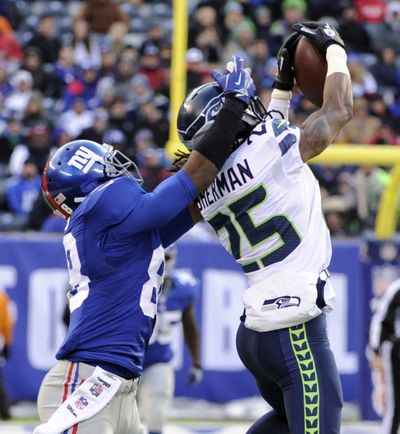  Richard Sherman, right, intercepts a pass from New York Giants quarterback Eli Manning, one of five interceptions for the Seahawks on Sunday.
 (Bill Kostroun / Fr51951 Ap)