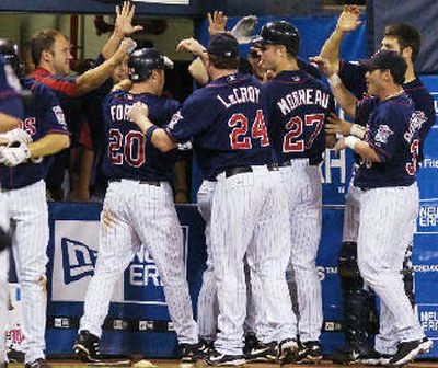 
Minnesota Twins' Lew Ford (20) is mobbed by teammates as he enters the Twins' dugout after hitting a three-run home run. 
 (Associated Press / The Spokesman-Review)