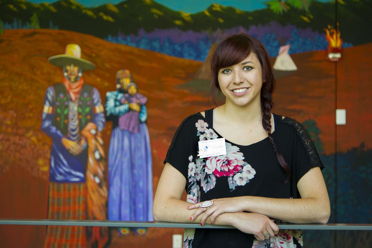 Klarissa Brittain of the Spokane Tribe of Indians is a tribal teen docent at the Museum of Arts and Culture. She stands in front of a mural by Ric Gendron, a member of the Colville and Umatilla tribes, known for his bold and colorful canvases. (Colin Mulvany)