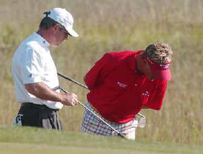 
Peter Lonard, left, helps Darren Clarke search for his ball – which he lost – on the 18th hole.
 (Associated Press / The Spokesman-Review)