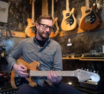 Eben Cole poses for a photo with one of his Cole Music Co. Hollowtop guitars at his shop on Wednesday, Jan. 25, 2017, in Spokane, Wash. (Tyler Tjomsland / The Spokesman-Review)