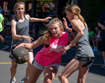 Team Don’t Sweat Me’s Brooklyn Parker 14, is double teamed by Halle Del Mese, 14, Grace Walsh of team Spokane Dawgs Elite during their Hoopfest game on Main Avenue, Saturday, June 25, 2022.  (COLIN MULVANY/THE SPOKESMAN)