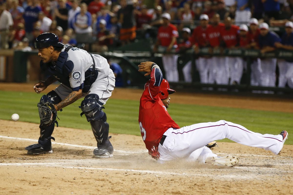 Engel Beltre slides home ahead of throw to Henry Blanco during Rangers’ four-run seventh inning. (Associated Press)