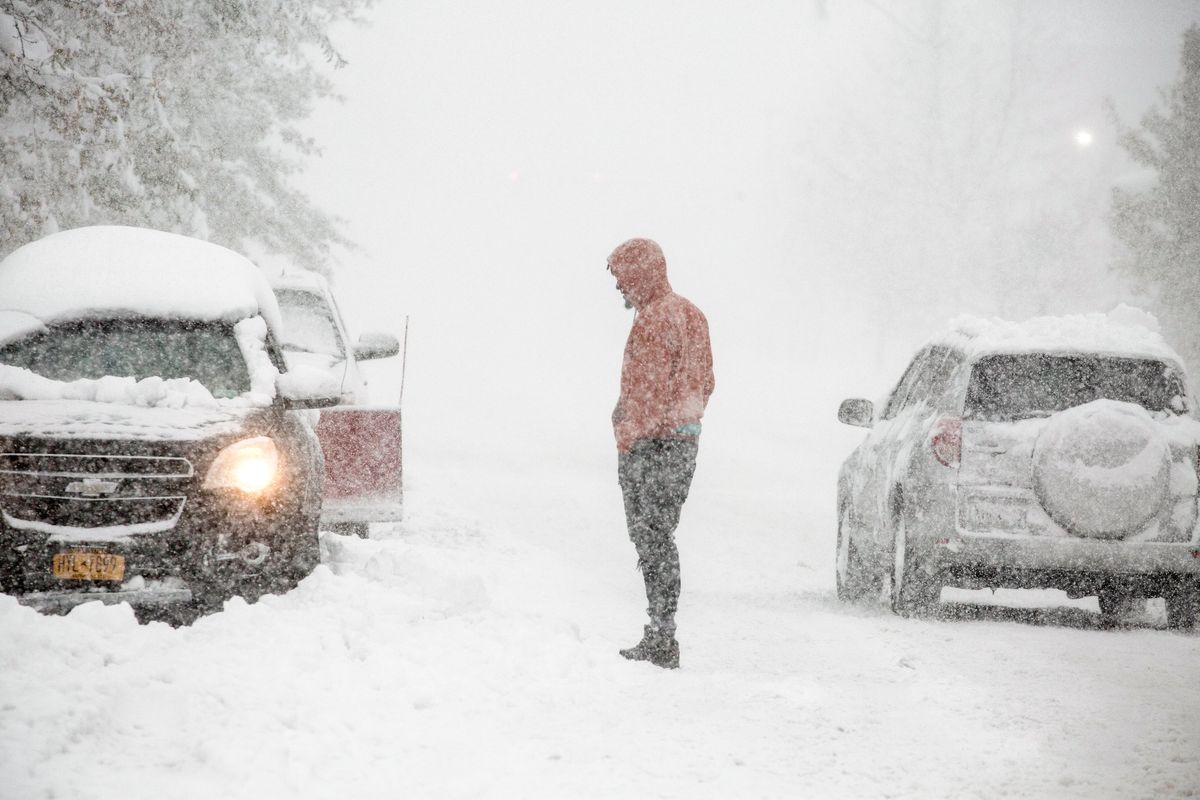 Pedestrians and drivers navigate white-out conditions during a blizzard in Buffalo, N.Y. on Friday, Nov. 18, 2022. A snow event lasting through the weekend is underway on the eastern coasts of Lakes Erie and Ontario, where two feet of snow and thundersnow have already been reported. (Brendan Bannon/The New York Times)  (BRENDAN BANNON)