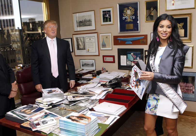 Donald Trump stands in his office as newly-crowned Miss USA Rima Fakih holds a magazine featuring Trump Thursday, May 20, 2010 in New York. (Jason Decrow / Fr103966 Ap)