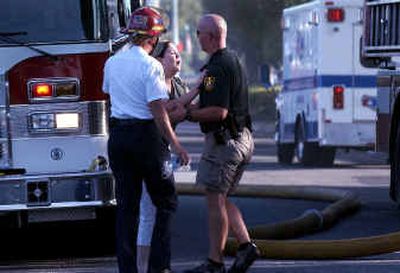 
Angela Jones is consoled by Randy Olson, a Spokane Valley EMS division chief, and Spokane Valley police Officer Andrew Buell on Tuesday in front of her rented home on Vista Road. Everything Jones and her two young daughters owned was in the house, she said.
 (Liz Kishimoto / The Spokesman-Review)