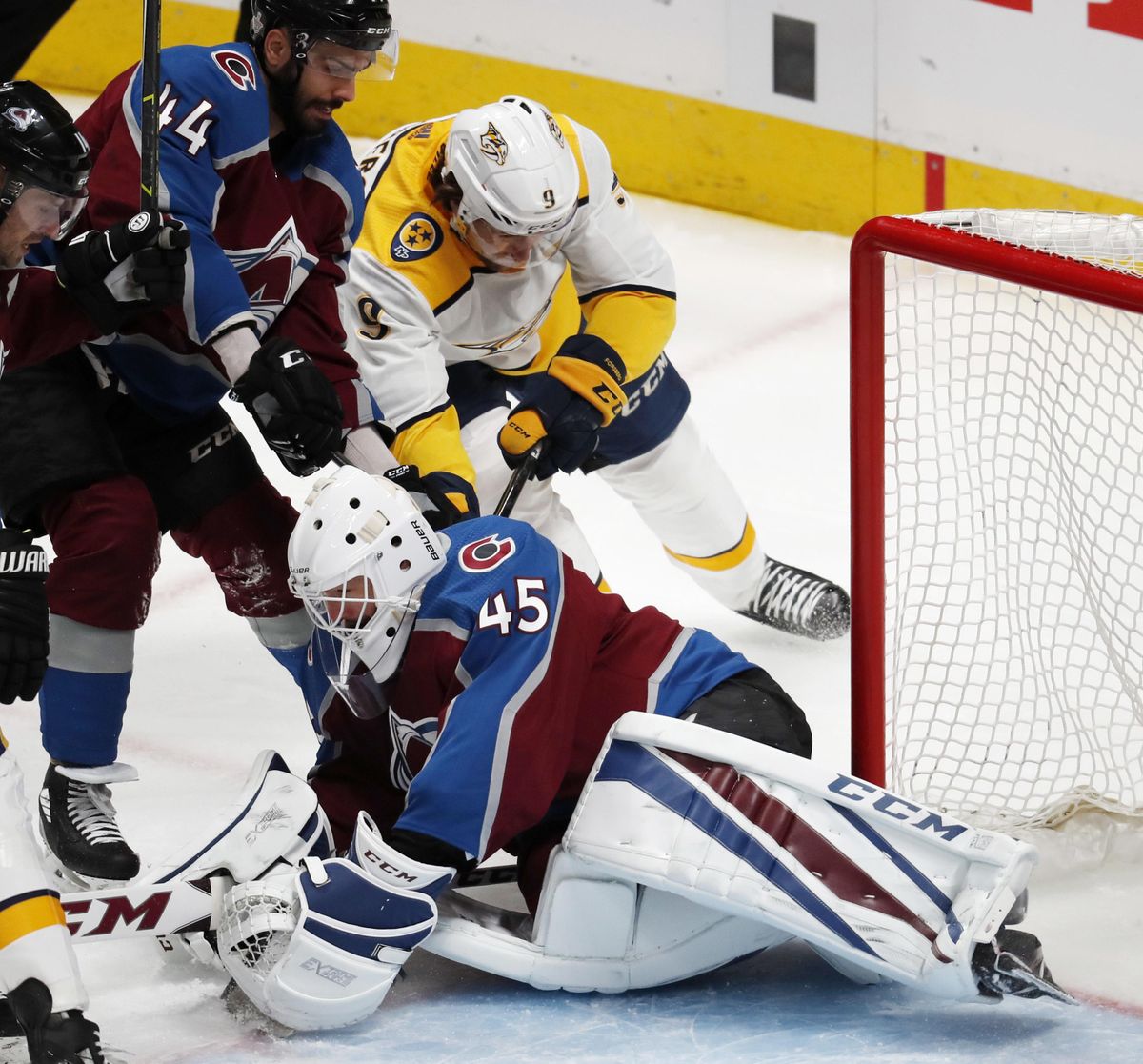 Colorado Avalanche goaltender Jonathan Bernier, front, falls on the ice to stop a shot by Nashville Predators left wing Filip Forsberg, back right, as Colorado defenseman Mark Barberio fights for position during the first period of Game 4 of an NHL hockey first-round playoff series Wednesday, April 18, 2018, in Denver. (David Zalubowski / Associated Press)