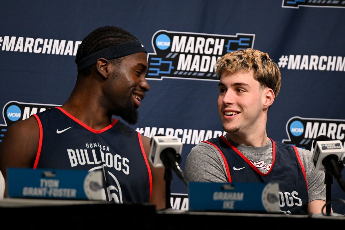 Gonzaga forward Graham Ike, left, and guard Mario Saint-Supery share a laugh during a news conference Friday before their NCAA Tournament matchup against Texas at Moda Center in Portland. (Tyler Tjomsland / The Spokesman-Review)