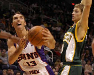 
Suns guard Steve Nash (13) is fouled by Seattle's Luke Ridnour, right, as he drives the lane during the second quarter. 
 (Associated Press / The Spokesman-Review)