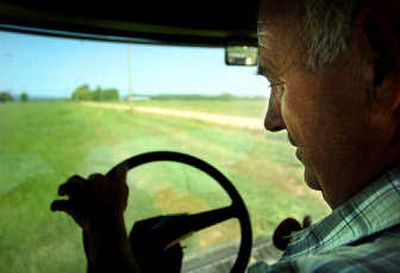 Paul Hudson, a farmer in Clayton, Wash., enjoys the air-conditioned cabin of his swather while cutting alfalfa last month.
(INGRID BARRENTINE / The Spokesman-Review)