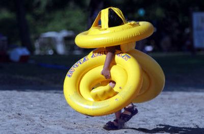 
Angel Moya, 3, of Santa Rosa, Calif., uses his head as he carries three floats up from the swimming lagoon over the weekend at Spring Lake Regional Park.
 (Associated Press / The Spokesman-Review)