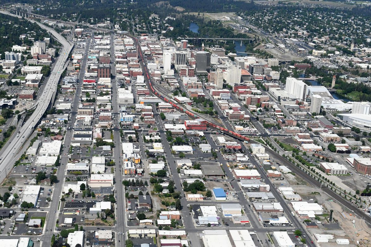 Looking west above downtown Spokane, the railroad tracks of the BNSF railroad can be seen angling from the lower right, past the old Northern Pacific Depot and continuing west toward Seattle. At far left, Interstate 90, completed in the late 1960s, represents Americans move away from rail travel. Around 1970, the NP merged with Great Northern and other lines to become Burlington Northern, which is now BNSF. Photo is from June 4, 2018. (Jesse Tinsley / The Spokesman-Review)