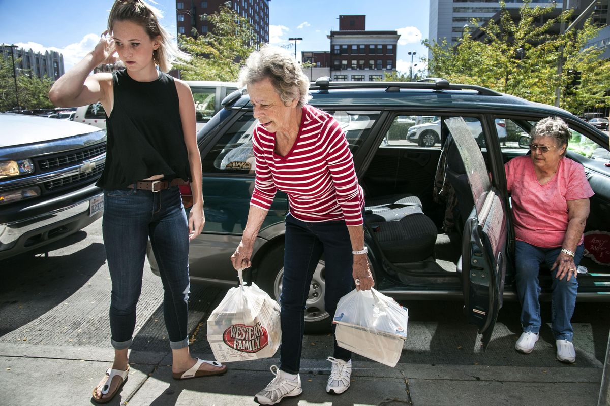 Gloria Alverson, of Spokane Valley, center, and Lucy Baker, right, of Spokane, drop off their second load of donations at the corner of Riverside and Howard in Spokane for the Cayuse Fire victims, Aug. 25, 2016. Alverson toured the Wellpinit area and saw the fire destruction. Volunteer Bailey Claassen is at left. (Dan Pelle / The Spokesman-Review)