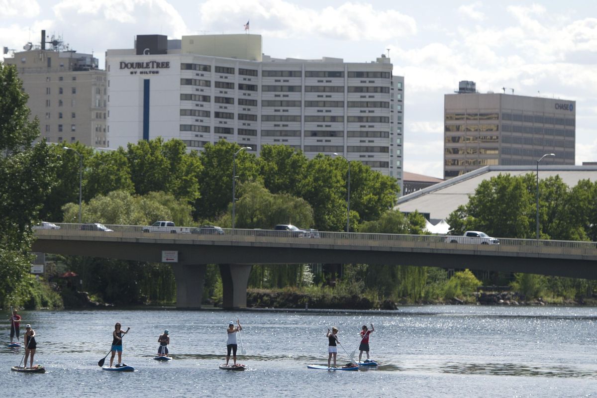 Paddle boarders float the Spokane River on a tour with Fun Unlimited on Wednesday, July 13, 2016, in Spokane, Wash. (Tyler Tjomsland / The Spokesman-Review)