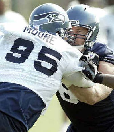 
Rashad Moore works against center Robbie Tobeck during drills. Moore was a big addition to the rotation. 
 (Associated Press / The Spokesman-Review)