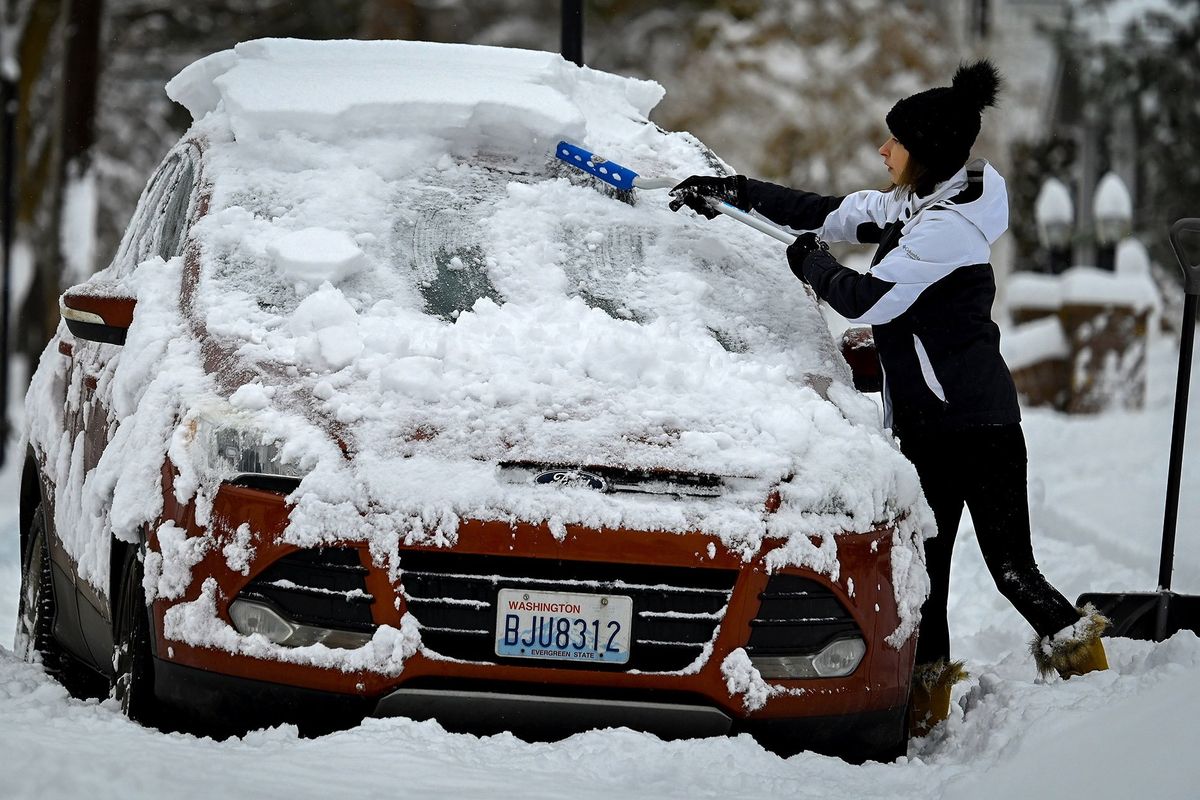 “Just when we thought it was over,” said Rachel Adams as she brushes the snow from her SUV in front of her house on West 27th Avenue Tuesday morning. The Spokane area received 4-6 inches of snow overnight.  (COLIN MULVANY/THE SPOKESMAN-REVIEW)