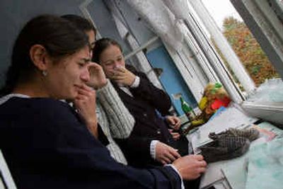 
Sixteen-year-old Alona Pliyeva, right, and her classmates cry while looking at children's shoes Tuesday in a windowsill at school No.1 in Beslan, Russia. Residents ended a formal mourning period since the end of the hostage-taking ordeal. 
 (Associated Press / The Spokesman-Review)