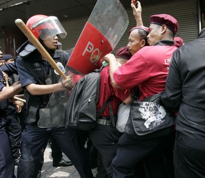 Protesters clash with riot police in Kuala Lumpur on Saturday. At least 10,000 marched in Malaysia’s capital to protest a law allowing detention without trial. (Associated Press / The Spokesman-Review)
