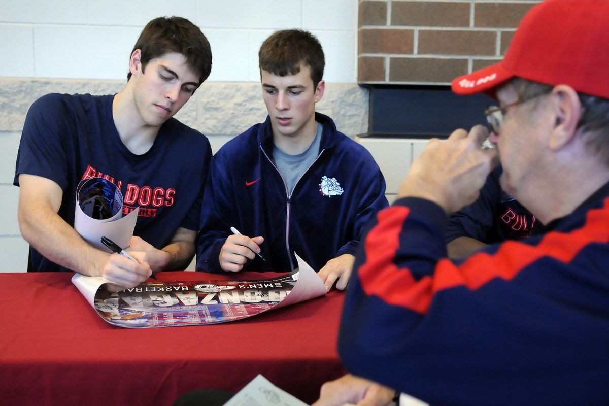 Gonzaga’s Mike Hart, left, and Kevin Pangos autograph posters for fans at McCarthey Athletic Center. (Dan Pelle)