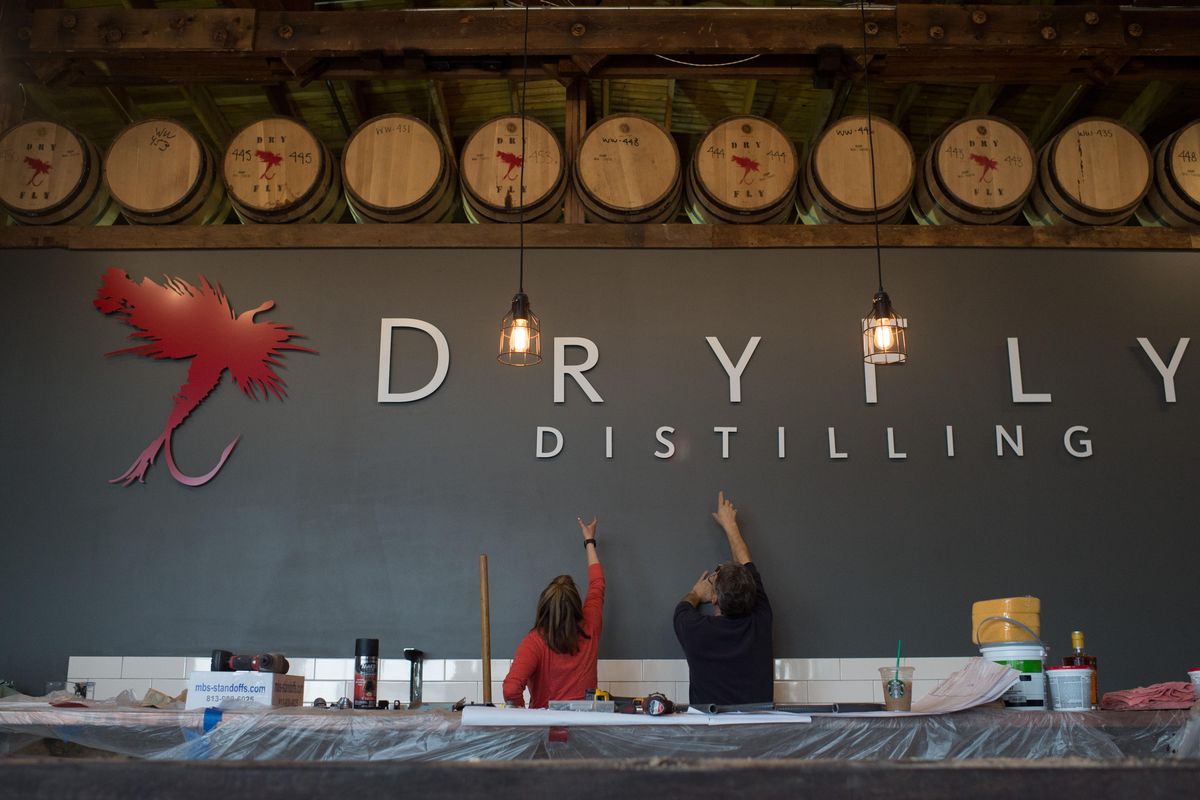 McGraw Donovan and Brad Barrick take measurements in the new Dry Fly Distilling tasting room Thursday in Spokane. (Tyler Tjomsland / The Spokesman-Review)