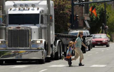 Pedestrians cross First Avenue in Sandpoint on Friday. The flow of commercial traffic on downtown streets is one reason planners have pursued a bypass.
(Jesse Tinsley / The Spokesman-Review)