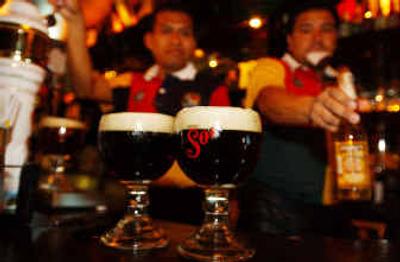 
Bartenders deliver beer at local bar in Mexico City. Corona Light is hugely popular in the United States, but isn't even available in Mexico, where light beer makes up less than 2 percent of the domestic beer market. 
 (Associated Press / The Spokesman-Review)