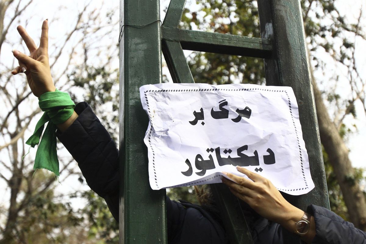 This photo  obtained by the AP  shows a protester  with a banner that reads “Death to the dictator.” An Iranian ban on foreign media prevented the AP from independent access to the event.