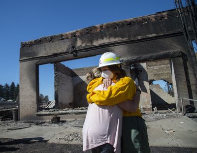 Washington Commissioner of Public Lands Hilary Franz, right, embraces Malden Mayor Chris Ferrell on Sept. 9 in front of a burned-out building in Malden, Washington. Franz toured the town and made the case for more funding for firefighting resources. Most of the buildings in Malden were destroyed by wind-driven wildfire Sept. 7. (Jesse Tinsley/The Spokesman-Review)