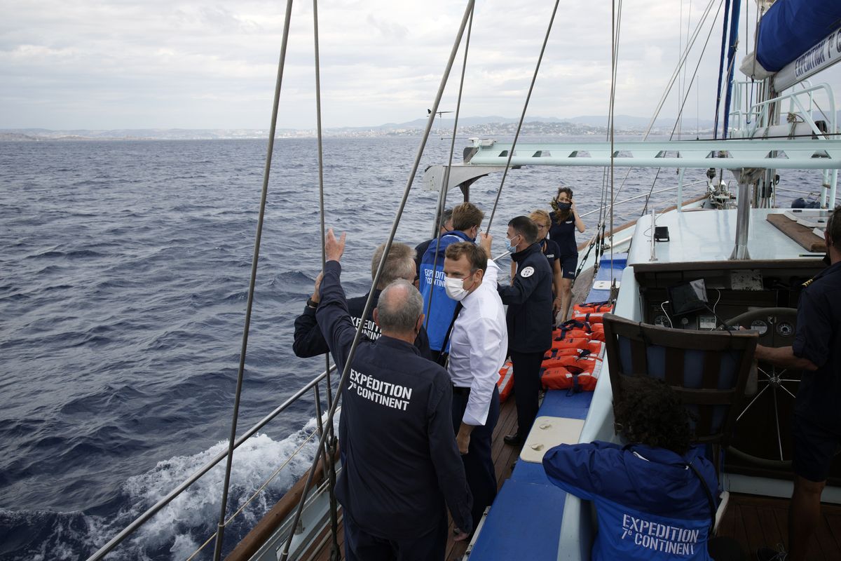French President Emmanuel Macron talks with the crew of the 7th Continent expedition sailing ship as they go admire the Calanques National Park, a marine reserve known for its azure blue waters, Friday.  (Daniel Cole)