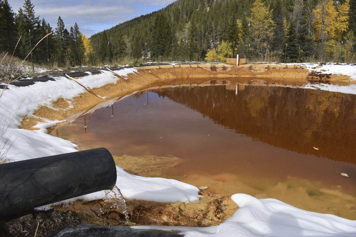 Water contaminated with arsenic, lead and zinc flows from a pipe out of the Lee Mountain mine and into a holding pond near Rimini, Mont., on Oct. 12, 2018. President Joe Biden’s $2.3 trillion plan to transform America’s infrastructure includes $16 billion to plug old oil and gas wells and to clean up abandoned mines.  (Matthew Brown/Associated Press)